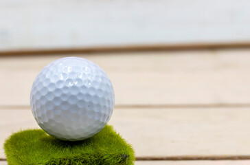 Golf ball is on wooden background