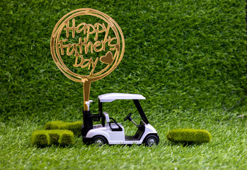 Golf cart with Happy Father's Day are on green grass