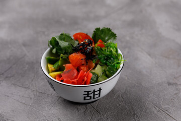Hawaiian food platter, in a bowl on a gray background. Pan-Asian cuisine to go or delivery in a container. Close-up