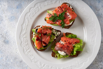 Tasty homemade sandwich with salmon ,greens and avocado