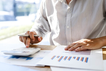 Managers are calculating by using a calculator to validate the company's income to bring it to the...