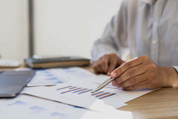 Businessman is reading monthly sales summary of each salesperson. He sits and works in his private office. Sales management concept.