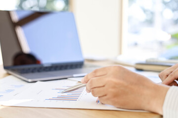 Businessman is reading monthly sales summary of each salesperson. He sits and works in his private office. Sales management concept.