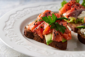 Tasty homemade sandwich with salmon ,greens and avocado