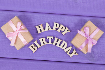 Wrapped gifts with ribbon for birthday. Inscription happy birthday on boards
