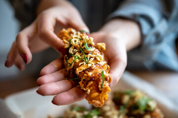 Korean fried chicken tender with hands holding