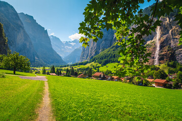 Fototapeta na wymiar Green fields and Lauterbrunnen valley with spectacular waterfalls, Switzerland