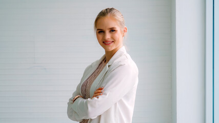 Attractive young woman profile portrait in office . Confident business person wearing formal suit working in corporate business.