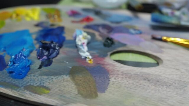 colorful oil paints on the palette. creative workplace of the artist.