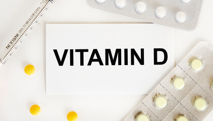 On the card text VITAMIN D, next to blisters with tablets and a syringe.