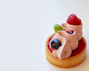 Close up of berry tartlet with fresh berries and whipped ganashe
