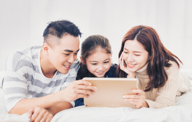 happy family watching the  digital tablet in bed