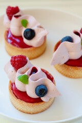 Close up of berry tartlets with fresh berries and whipped ganashe