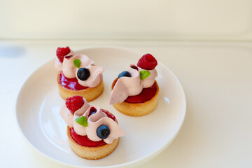 Obraz premium Close up of berry tartlets with fresh berries and whipped ganashe