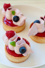 Close up of berry tartlets with fresh berries and whipped ganashe
