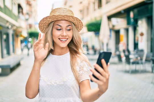 Young caucasian tourist girl doing video call using smartphone at city.