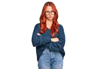 Young redhead woman wearing casual sweater and glasses skeptic and nervous, disapproving expression...