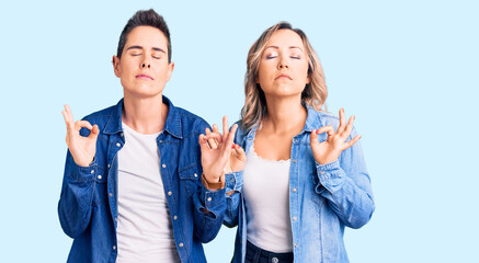 Couple of women wearing casual clothes relaxed and smiling with eyes closed doing meditation gesture with fingers. yoga concept.