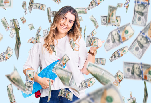 Young caucasian woman holding skate smiling happy pointing with hand and finger to the side