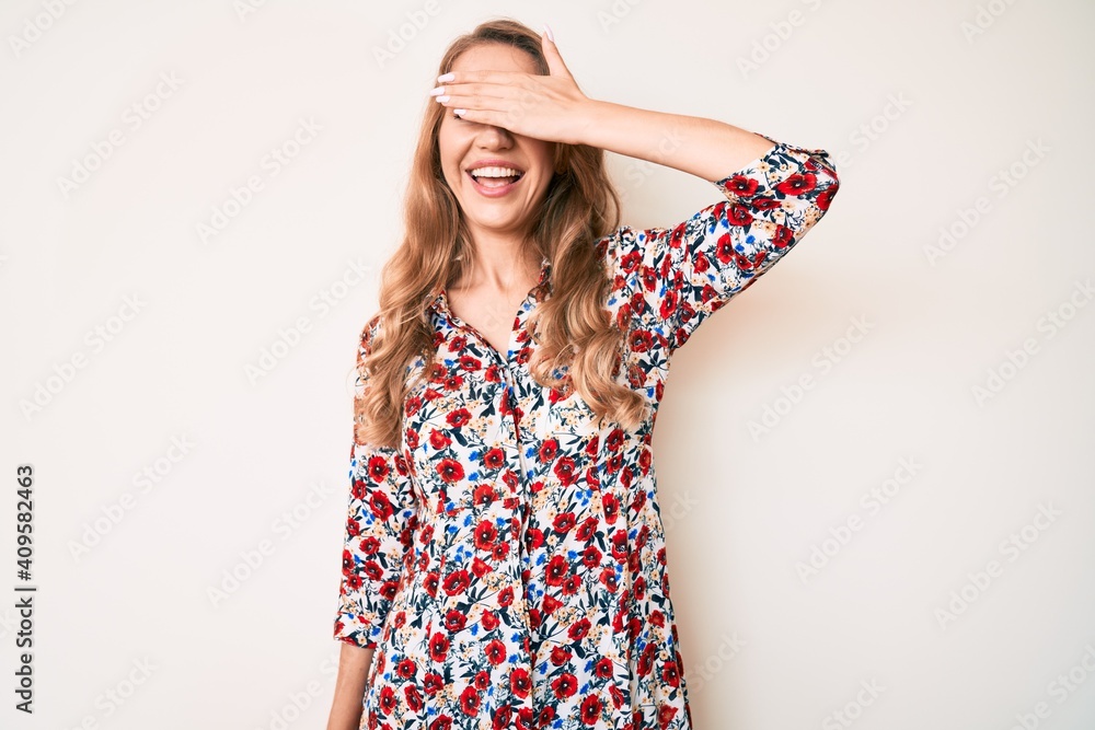 Canvas Prints Young caucasian woman with blond hair wearing summer dress smiling and laughing with hand on face covering eyes for surprise. blind concept.