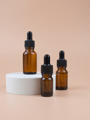 Naklejka premium Brown glass bottles with serum, essential oil or other cosmetic product. Natural organic cosmetic packaging, skin care concept.