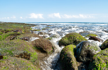 Fototapeta na wymiar Ocean current rushing over rocks on beach - Bali, Indonesia