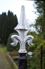 Corner fence decoration with a white fleur de lis made of iron 