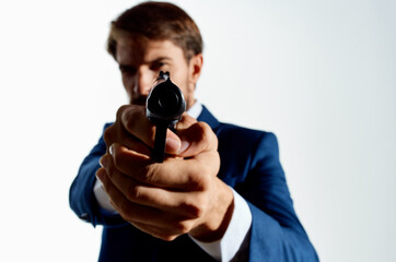 bearded man in suit gun close up killer murder light background