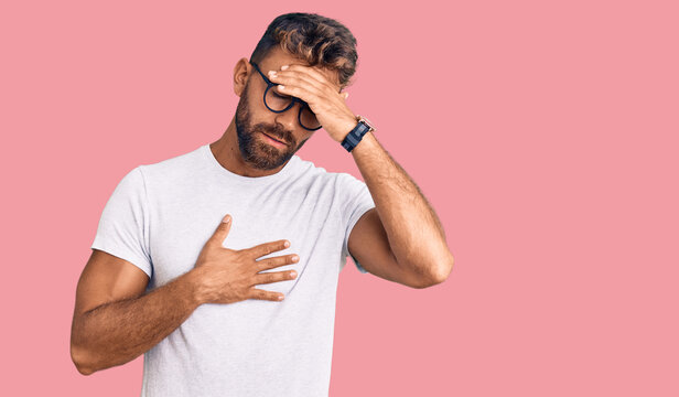 Young hispanic man wearing casual clothes and glasses touching forehead for illness and fever, flu and cold, virus sick