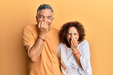 Beautiful middle age couple together wearing casual clothes laughing and embarrassed giggle...