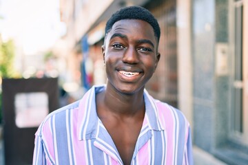 Young african american man smiling happy standing at street of city.