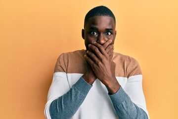 Young african american man wearing casual clothes shocked covering mouth with hands for mistake. secret concept.