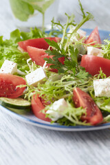 	
Salad with Green Olives, Tomatoes and Feta Cheese. Bright wooden background.