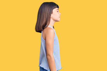 Young little girl with bang wearing casual clothes looking to side, relax profile pose with natural face with confident smile.