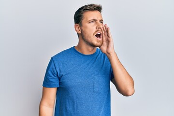 Fototapeta premium Handsome caucasian man wearing casual clothes shouting and screaming loud to side with hand on mouth. communication concept.