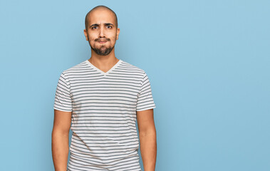 Hispanic adult man wearing casual clothes puffing cheeks with funny face. mouth inflated with air,...