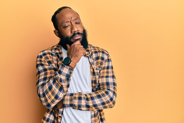 Young african american man wearing casual clothes thinking concentrated about doubt with finger on...