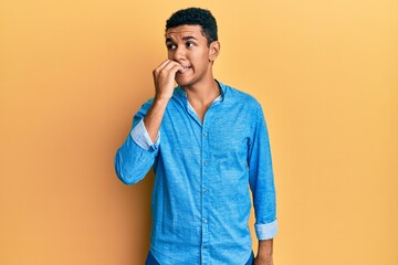 Young arab man wearing casual clothes looking stressed and nervous with hands on mouth biting...