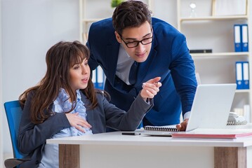 Pregnant woman struggling in the office and getting colleague he