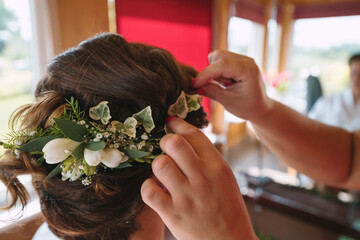 Fototapeta premium A bride at hairdressing salon making wedding headdress. Hands touching a hair of bride