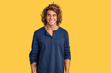 Young hispanic man wearing casual clothes winking looking at the camera with sexy expression,...