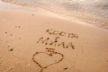 Declaration of love on the sand of the beach. Lettering names equals love