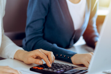 Accountant checking financial statement or counting by calculator income for tax form, hands...