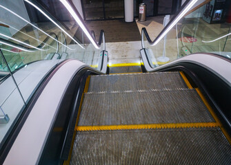 escalator with a moving staircase in the shopping center at the exit from the underground parking