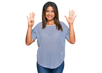 Obraz premium Young latin girl wearing casual clothes showing and pointing up with fingers number nine while smiling confident and happy.