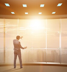 Businessman in front of office window thinking of new challenges