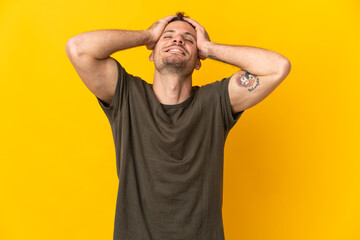 Fototapeta na wymiar Young caucasian handsome man isolated on yellow background laughing