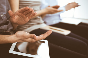 Obraz premium Business people clapping at meeting or conference, close-up of hands. Group of unknown businessmen and women in modern white office. Success teamwork, corporate coaching and applause concept