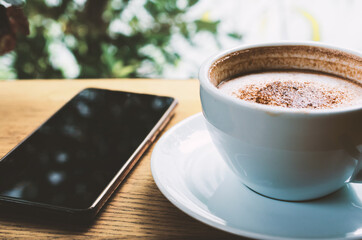closeup coffee cup on wood table bar in restaurant or cafe with copy space. fresh beverage.