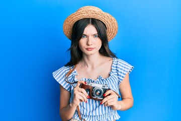 Young beautiful caucasian girl holding vintage camera skeptic and nervous, frowning upset because of problem. negative person.